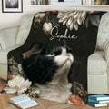 Tuxedo cat throw blanket with botanical flowers draped across a cozy living room sofa