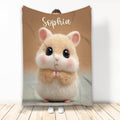 Cute hamster throw blanket displayed upright with soft cream and tan animal artwork