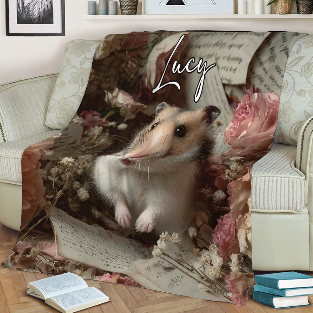 Hamster throw blanket styled across a sofa with soft floral artwork and vintage paper details