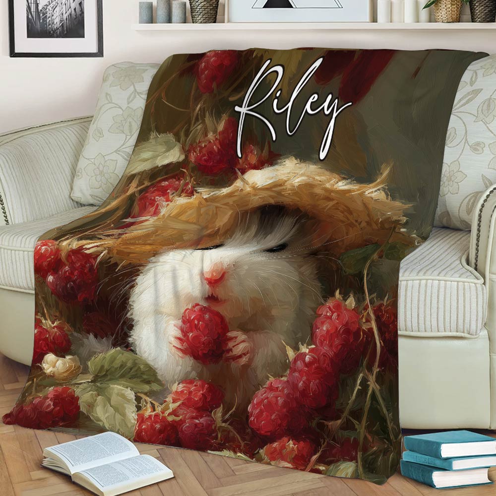 Whimsical hamster wearing a straw hat on a berry-themed blanket in an armchair setting