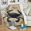 Crab blanket draped over a sofa in a cozy reading space with vintage collage artwork and coastal colors