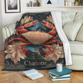 Crab throw blanket draped over a sofa, featuring illustrated red crab artwork, flowers, blue leaves, and an ornate border