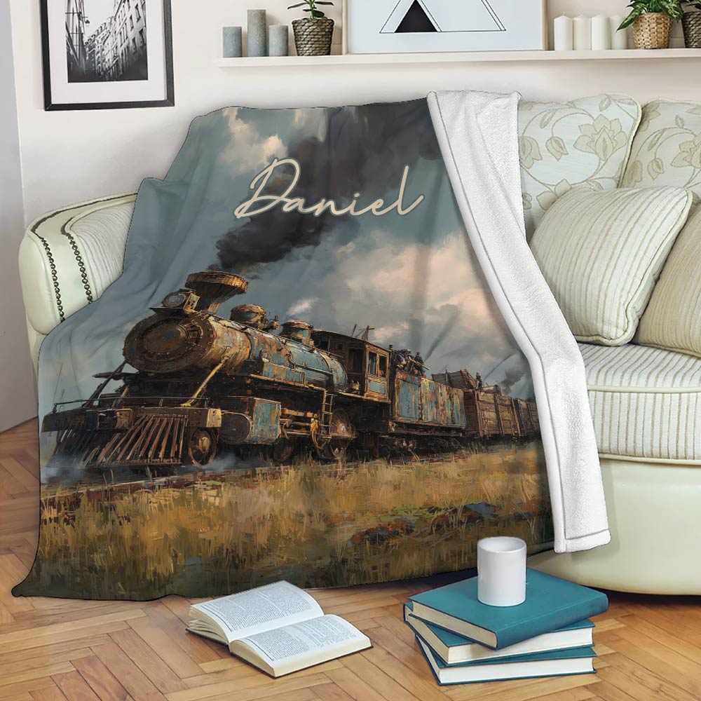 Railroad throw blanket draped over a sofa with vintage locomotive artwork and scenic countryside