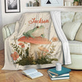 Frog blanket draped over a sofa with mushroom, flower, and botanical artwork