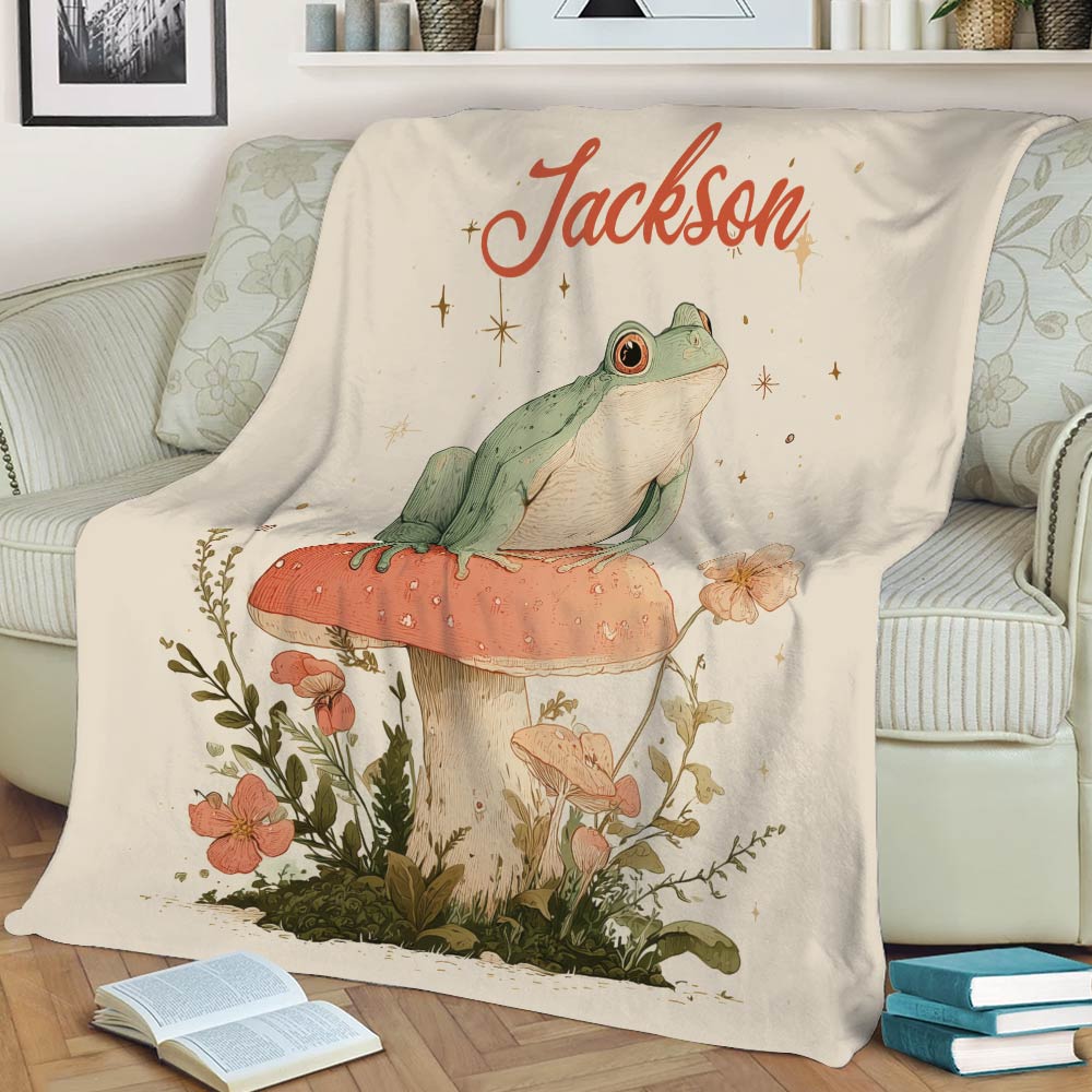 Frog throw blanket displayed on a couch with floral woodland illustration