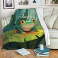 Frog blanket displayed on a sofa with vibrant green foliage, lily pads, and colorful nature artwork