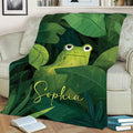Tropical frog blanket displayed across a sofa with vibrant layered jungle foliage