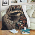 Raccoon blanket draped over a sofa, showing woodland wildlife artwork in a cozy reading space