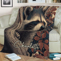 Close view of a raccoon throw blanket displayed on a sofa with forest foliage and tree artwork