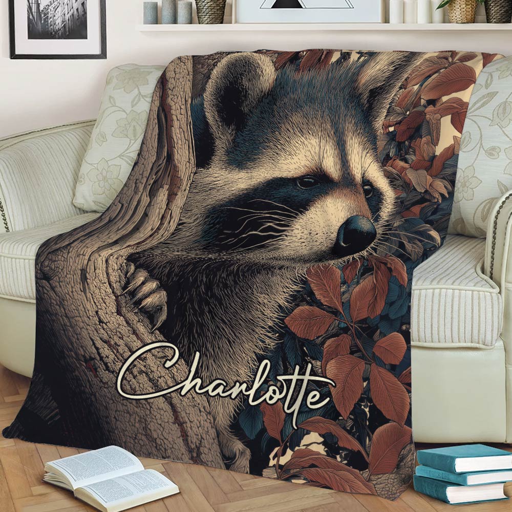 Close view of a raccoon throw blanket displayed on a sofa with forest foliage and tree artwork