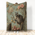 Raccoon blanket with vintage floral orchard artwork displayed as a cozy room accent