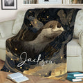 Decorative otter throw blanket displayed on a sofa with flowing gold and navy artwork
