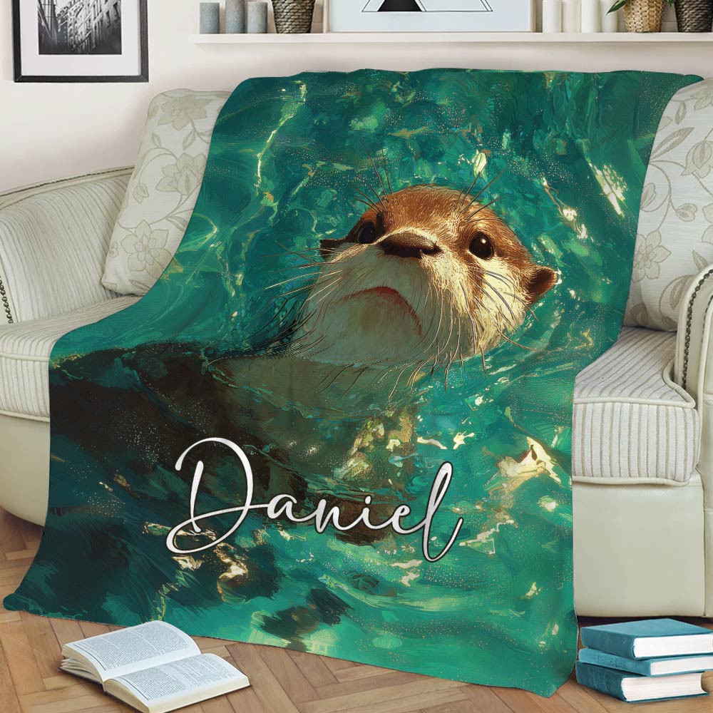 Otter throw blanket displayed on a sofa with an expressive otter surrounded by abstract water