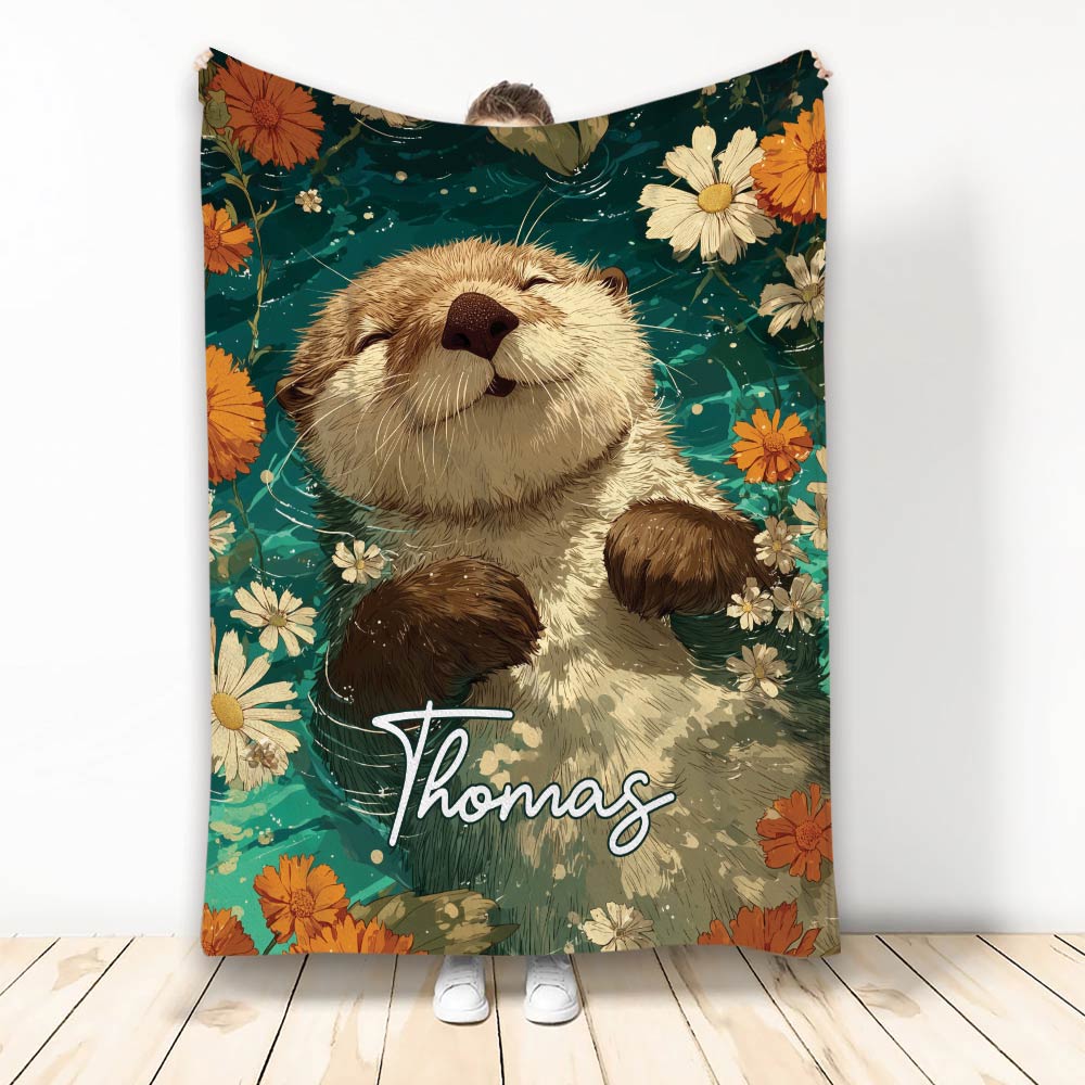 Otter throw blanket featuring a playful illustrated otter surrounded by orange and cream flowers