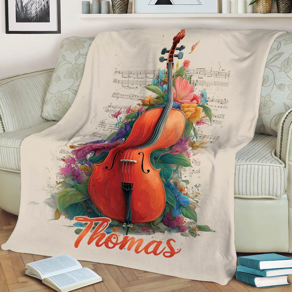 Close view of cello artwork with colorful flowers and sheet music on a cozy throw blanket