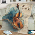 Cello blanket styled on a sofa, featuring a warm wooden cello against artistic sheet music