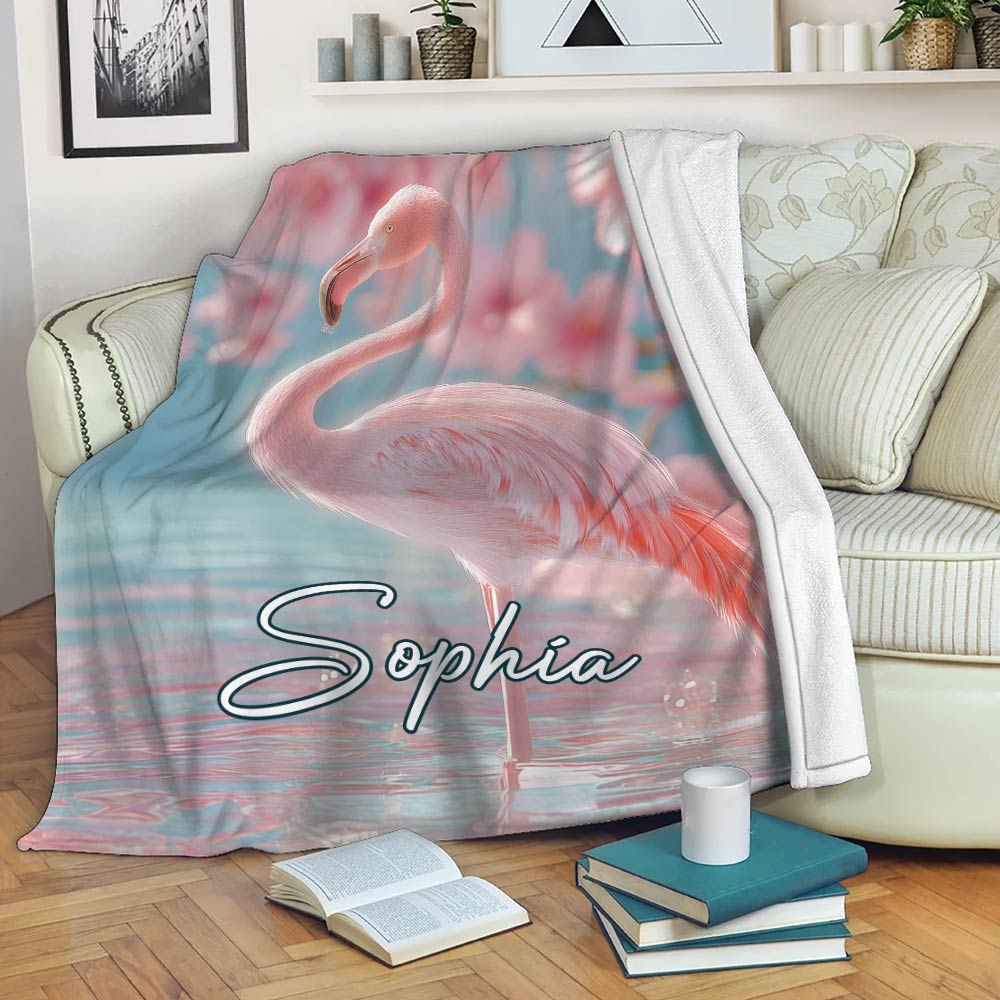 Flamingo throw blanket draped over a sofa with pink and blue tropical artwork