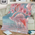Large pink flamingo blanket styled across a sofa with pastel aquatic scenery