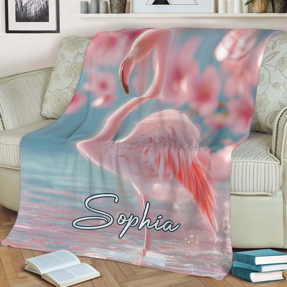 Large pink flamingo blanket styled across a sofa with pastel aquatic scenery
