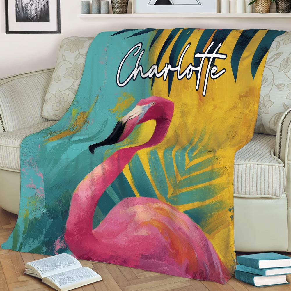 Bright pink flamingo blanket styled across a sofa with teal and gold foliage
