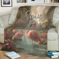 Tropical flamingo throw blanket displayed on a sofa with pink birds, palm trees, and lush flowers