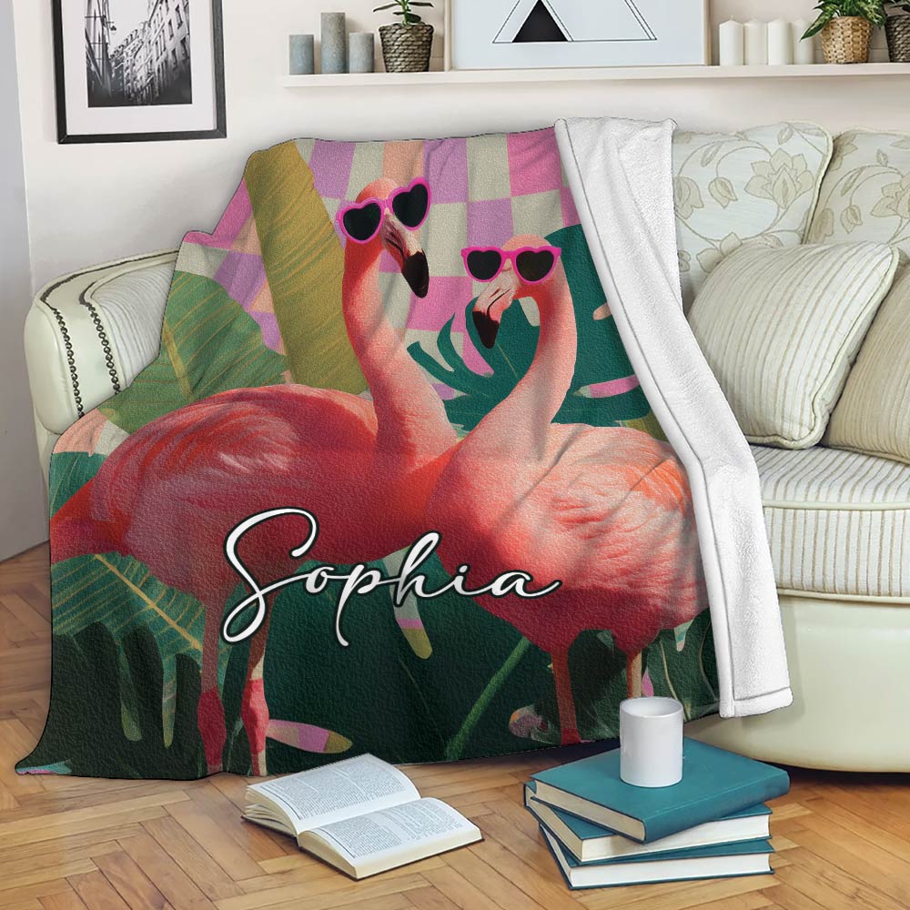 Flamingo throw blanket displayed on a sofa with tropical foliage, pink accents, and colorful bird artwork