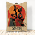 African throw blanket featuring four stylized figures in patterned clothing against warm red and gold artwork
