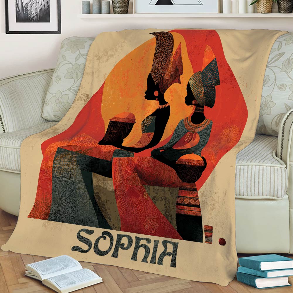 Close view of an African art throw blanket with stylized figures, traditional patterns, and bold sunset colors