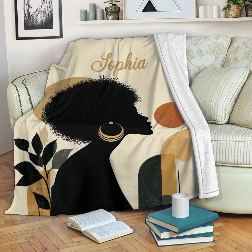 African art throw blanket displayed on a sofa with a Black woman silhouette and earthy geometric artwork