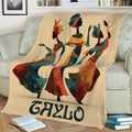 Colorful African-inspired blanket displayed on a couch with three dancing women