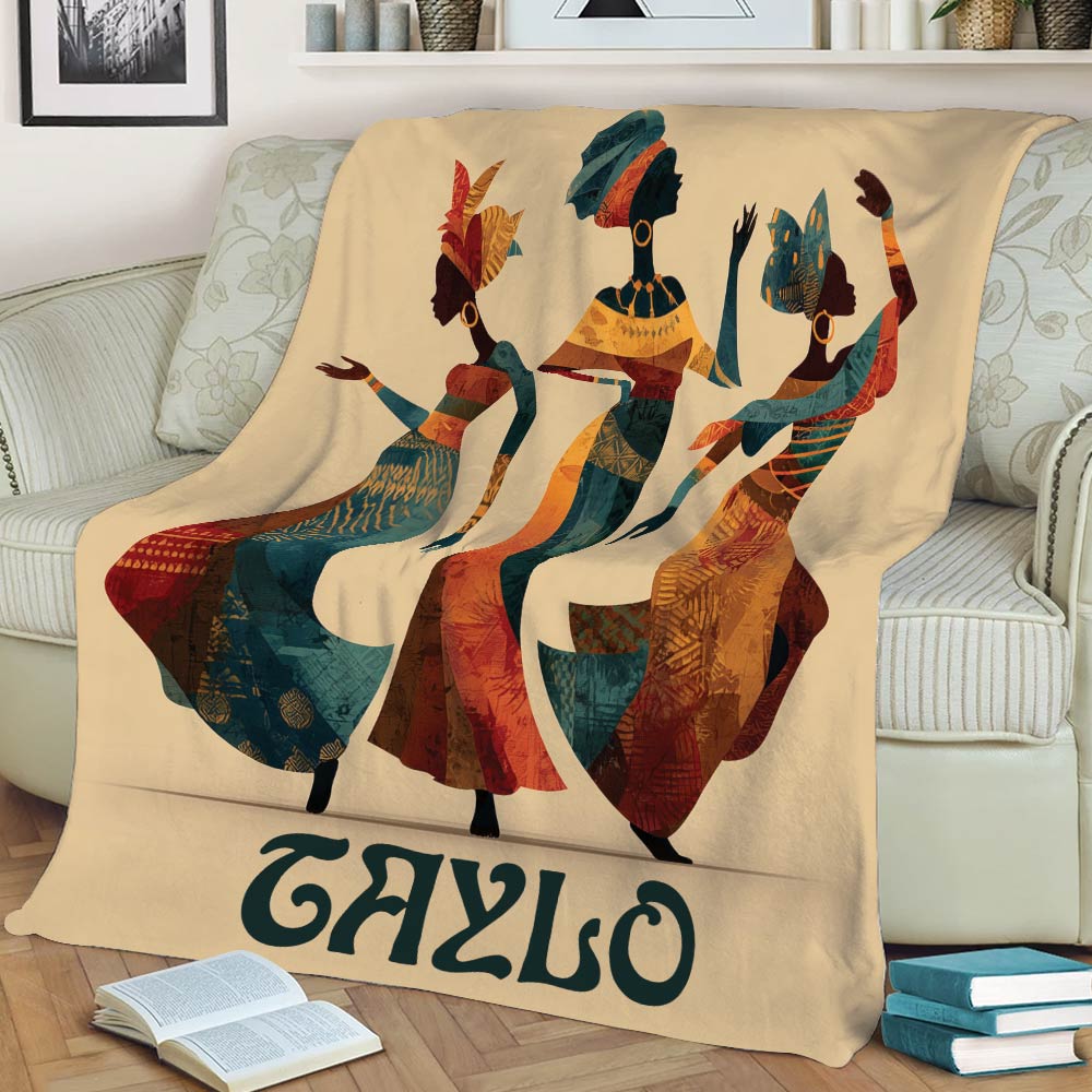 Colorful African-inspired blanket displayed on a couch with three dancing women