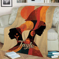 African art throw blanket draped over a sofa, featuring two female silhouettes and warm geometric colors