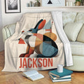 Colorful geometric rabbit blanket styled on a sofa in a cozy living room