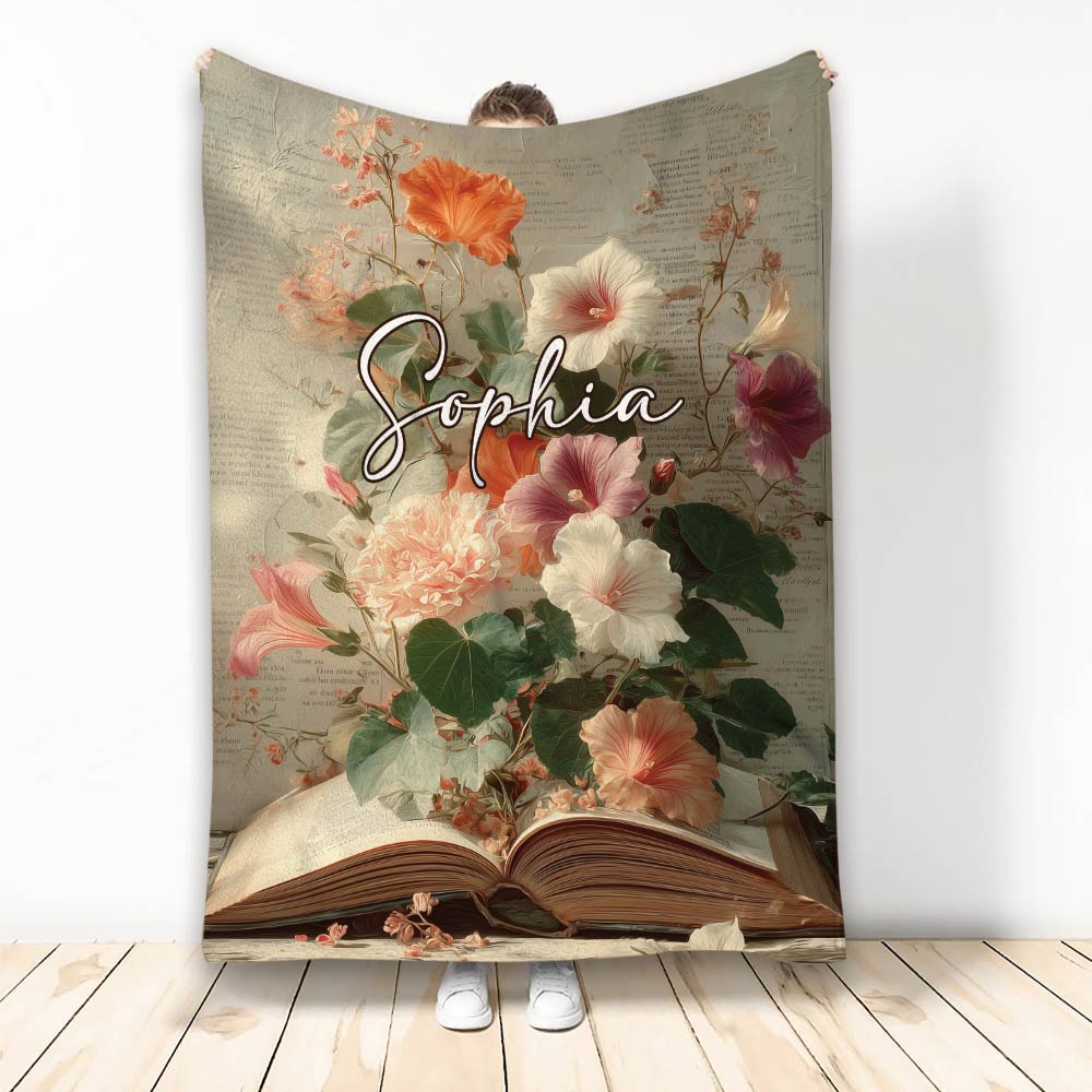 Floral book-themed throw blanket displayed upright with an open book and vintage page background