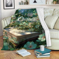 Literary garden throw blanket draped over a sofa with an open book and stacked books nearby