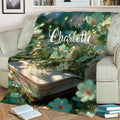 Book lover throw blanket displayed on a couch with open-book and floral artwork