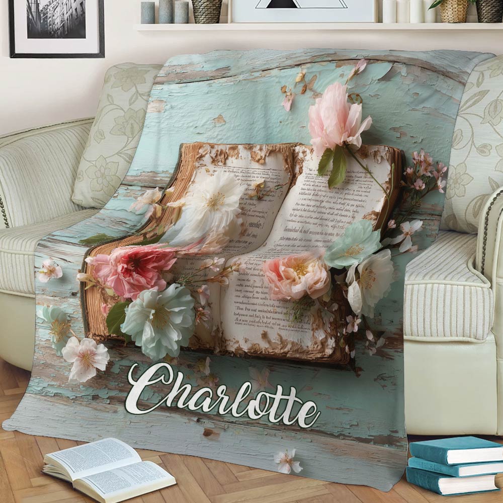 Close view of an open book and pastel flowers on a decorative reading blanket
