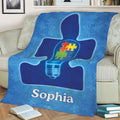 Blue autism awareness blanket draped over a couch with glowing puzzle-piece artwork