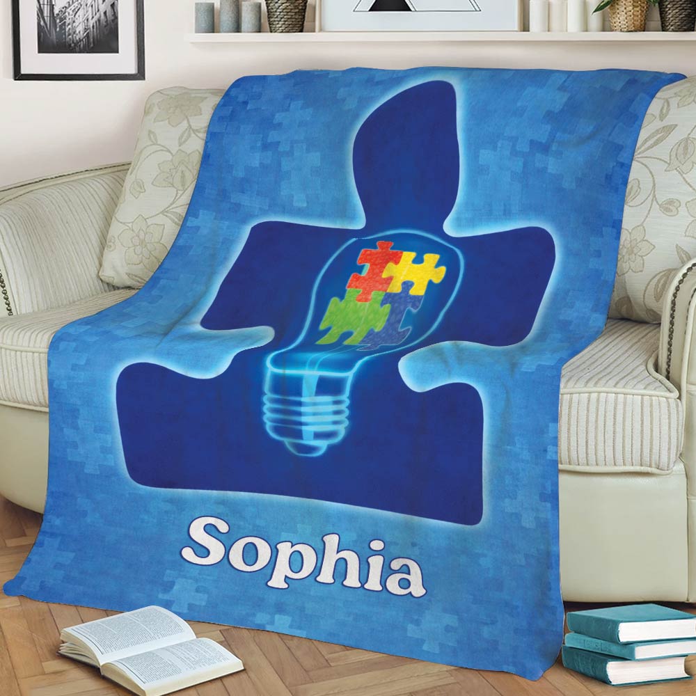 Blue autism awareness blanket draped over a couch with glowing puzzle-piece artwork
