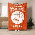 Orange basketball throw blanket shown hanging in a living room with a large white basketball graphic