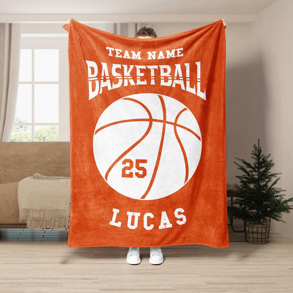 Orange basketball throw blanket shown hanging in a living room with a large white basketball graphic