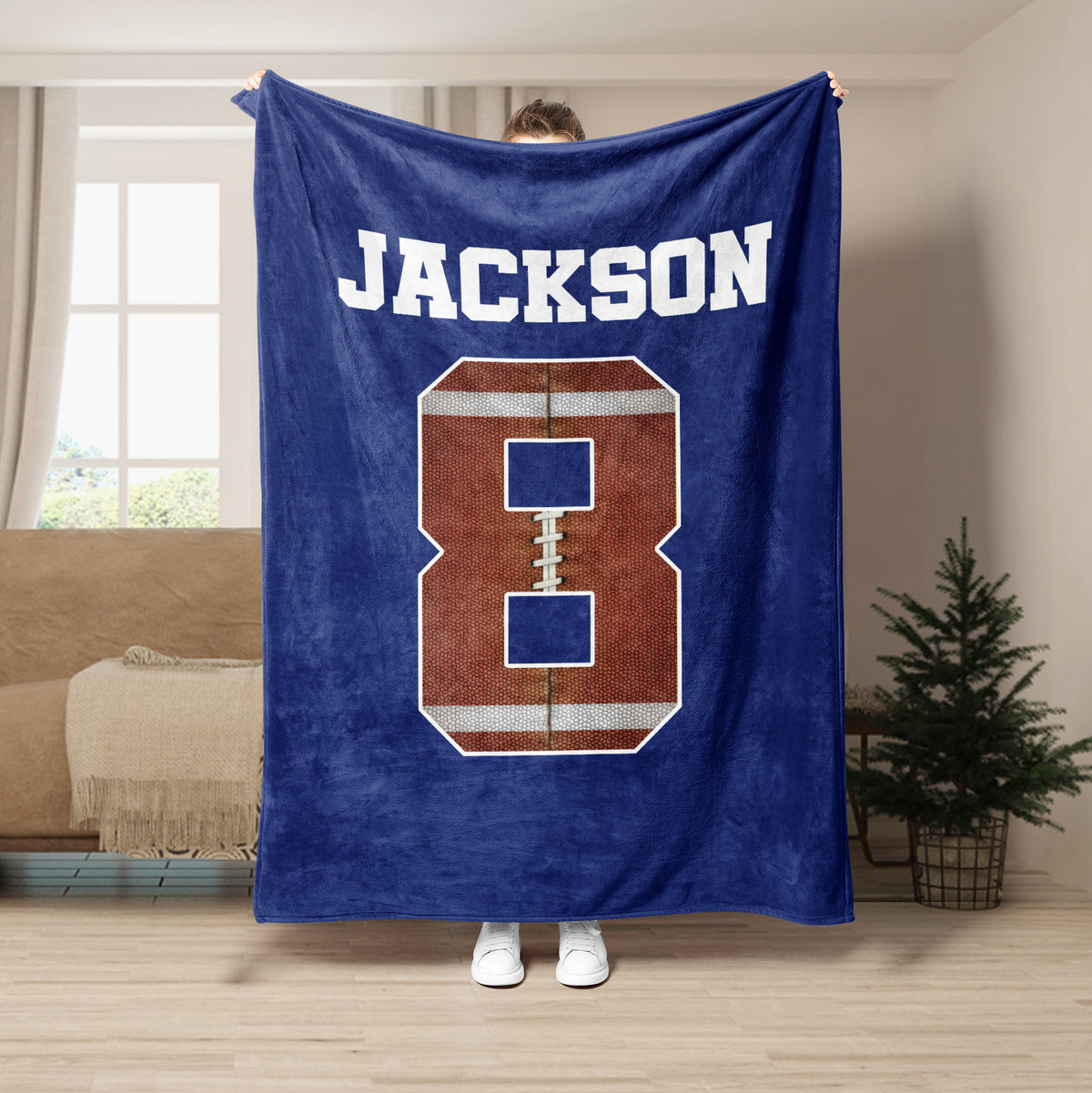 Navy football throw blanket featuring a large textured football graphic in a living room