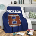 Navy football throw blanket draped over a sofa in a cozy living room