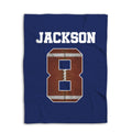 Navy football blanket shown flat with a large textured football design