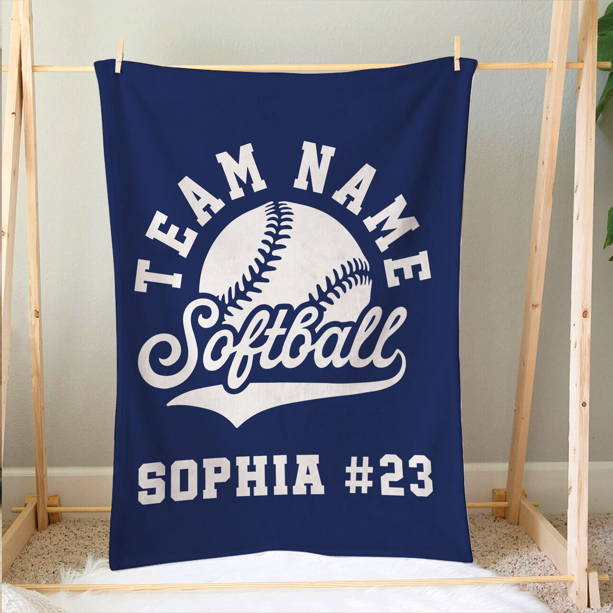 Softball blanket hanging in a bedroom display with bold white softball artwork on a navy background
