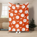Orange basketball blanket displayed in a room with repeating white basketball artwork