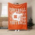 Orange football blanket displayed in a bright living room with helmet artwork