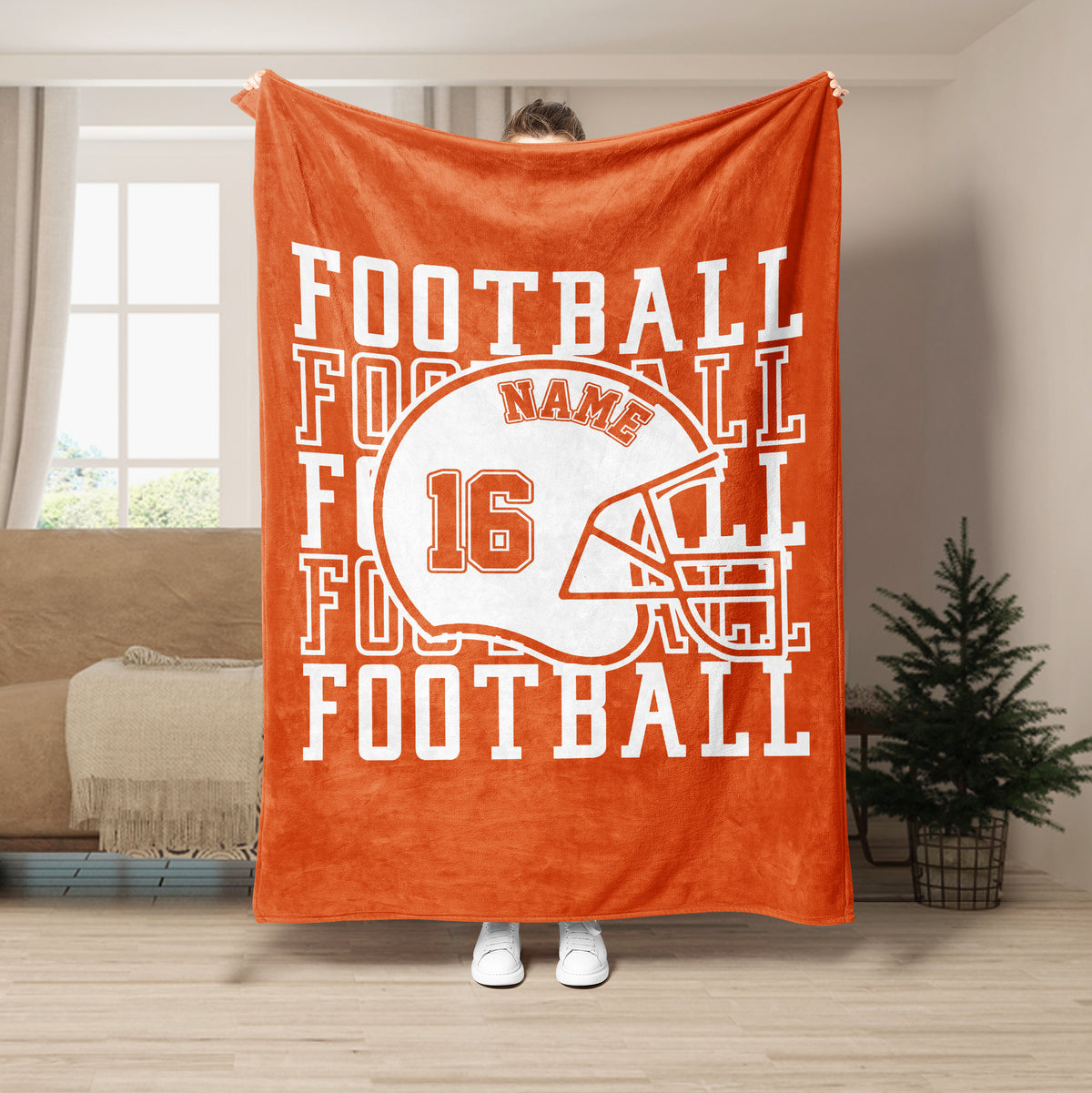 Orange football blanket displayed in a bright living room with helmet artwork