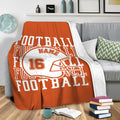 Orange football throw blanket draped over a gray sofa in a cozy living room