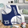 Navy softball throw blanket draped over a gray sofa in a cozy living room